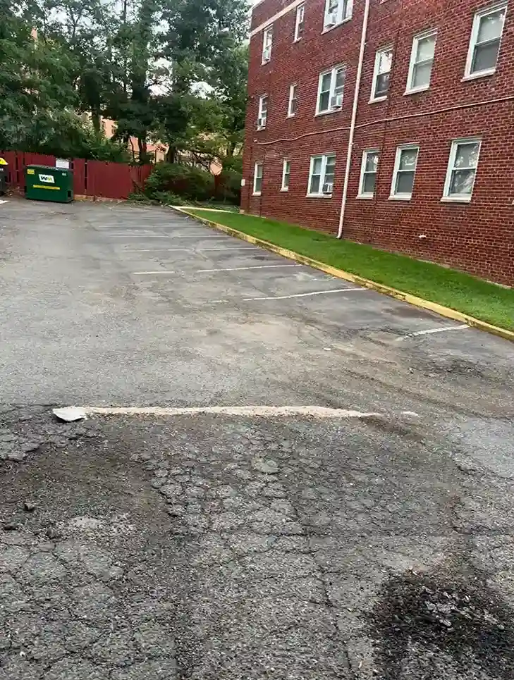 Worn asphalt parking lot in Arlington, VA before paving