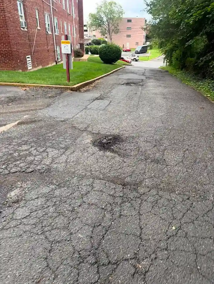 Cracked and patched asphalt parking area in Arlington, Virginia before paving